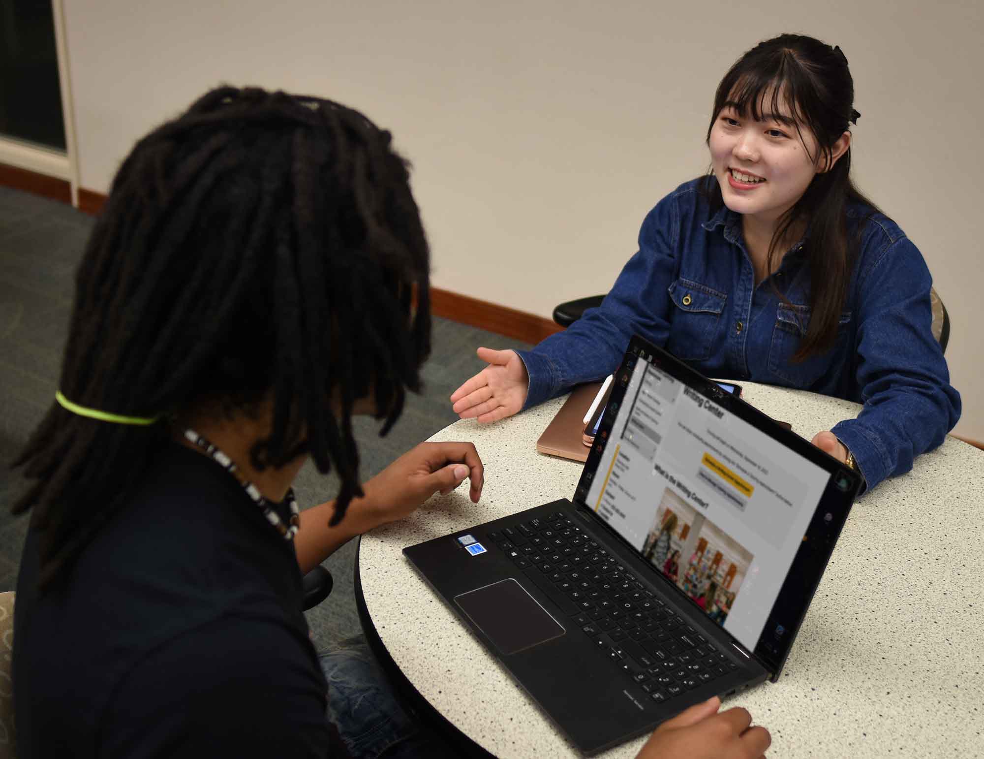 A tutor instructing a student in a library